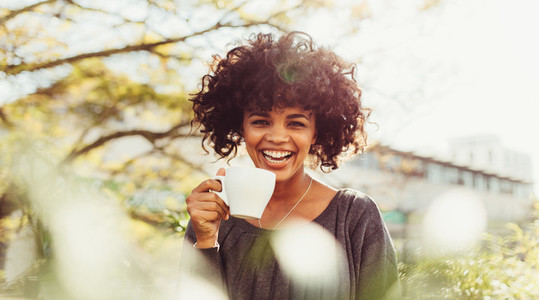 Portrait of a happy young woman drinking coffee