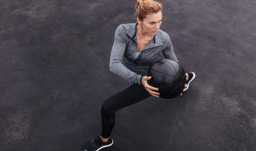 Fit woman exercising outdoors with medicine ball