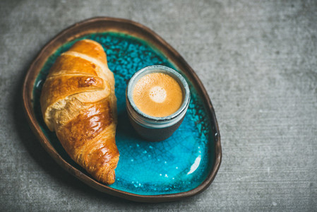 Cup of espresso coffee and croissant in tray  copy space