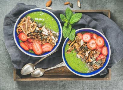Healthy green smoothie breakfast bowls with granola fruit seeds berries