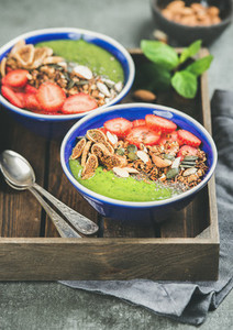 Green smoothie bowls with seeds nuts fruit and fresh berries