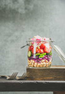 Healthy layered take away salad with vegetables and chickpea sprouts