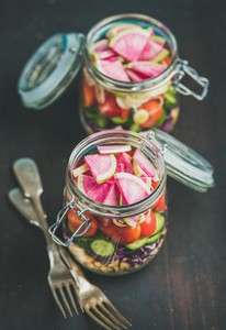Vegetable and chickpea sprout vegan salad in jars dark background
