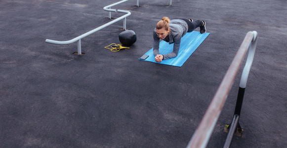 Fitness woman doing push ups at outdoor gym