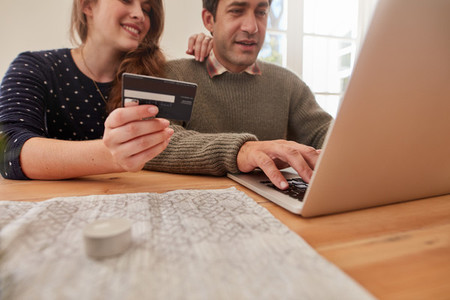 Young couple at home shopping online with credit card