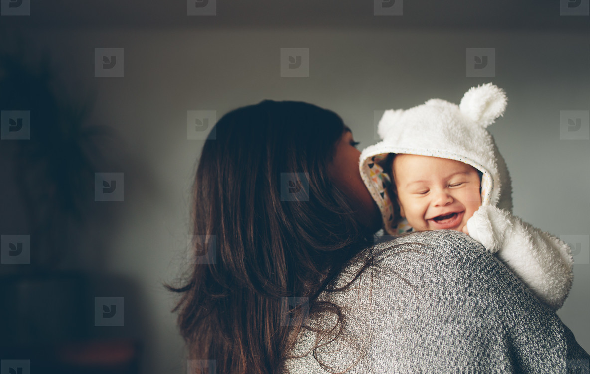 Cute little boy smiling in his mother s arms