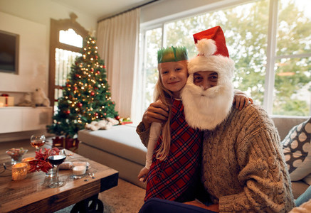 Beautiful little girl with santa claus at home