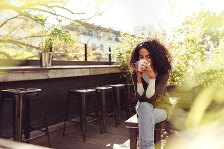 Woman drinking coffee at a coffee shop