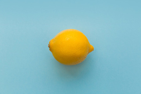 Yellow lemon fruit on bright blue background