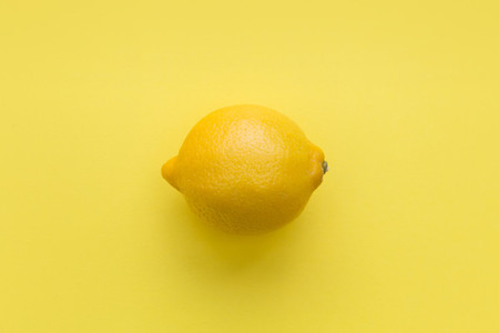 Lemon fruit on bright yellow background