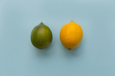 Lemon and lime fruits on bright blue background