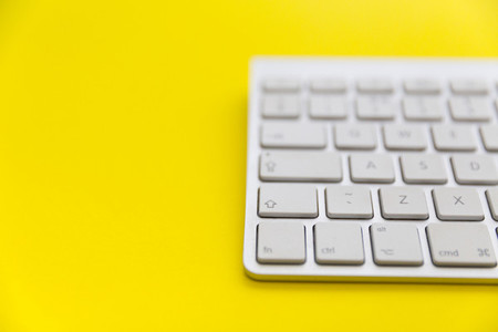 Wireless computer keyboard on bright yellow background