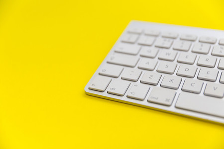 Computer keyboard on bright yellow background