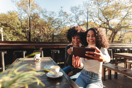 Two women having fun taking a selfie outdoors