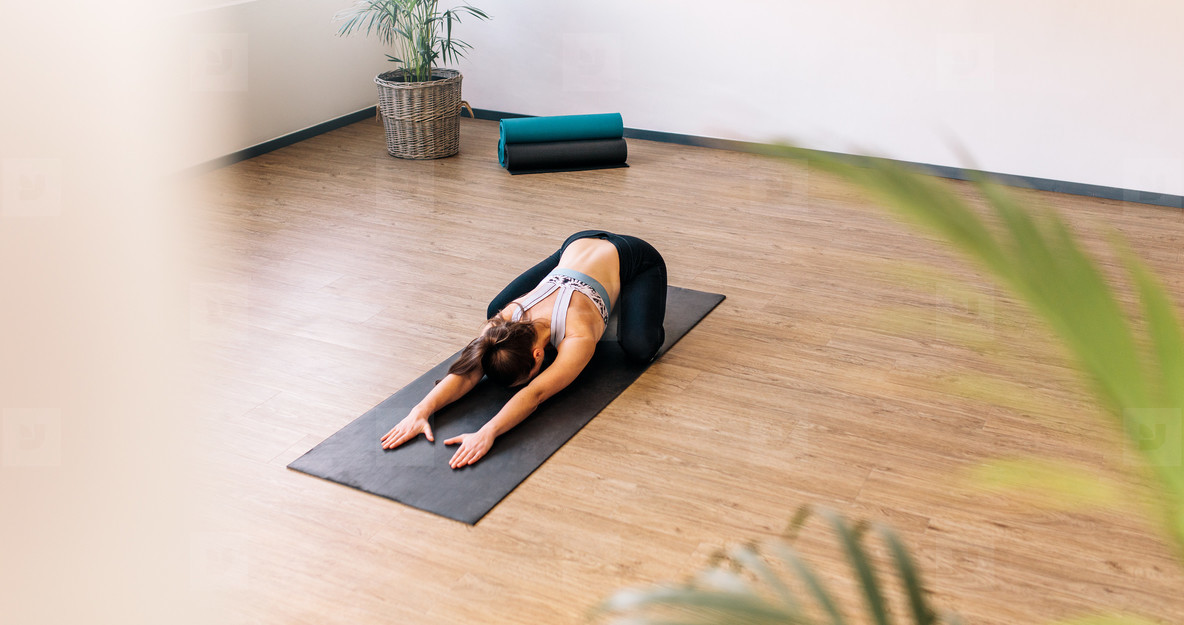 Healthy woman exercising on yoga mat indoors