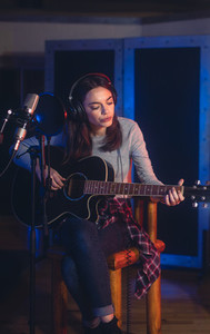 Female singer recording in professional music studio