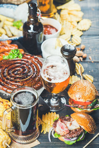Beer and snack set on dark wooden scorched background
