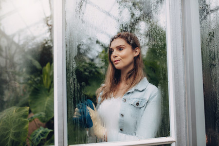 Female standing inside greenhouse