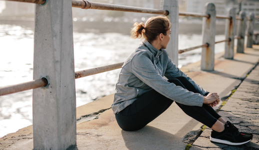 Woman relaxing at seaside promenade after workout