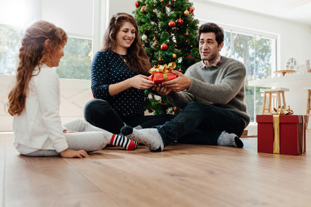 Young couple celebrating Christmas with their daughter
