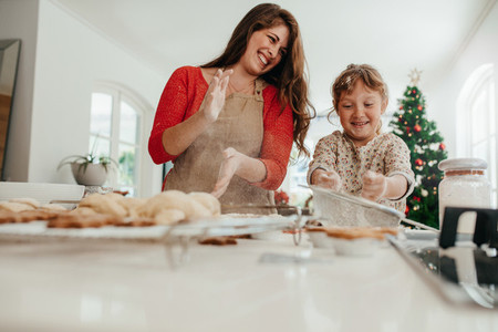 Mother and daughter having fun while making Christmas cookies