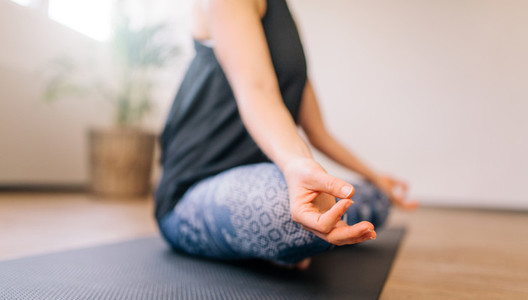 Woman in lotus yoga pose indoors