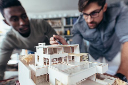 Two architects making architectural model in office