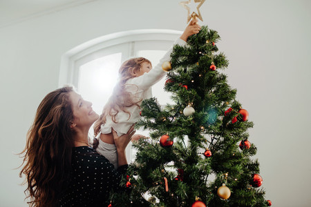Mother and child decorating Christmas tree