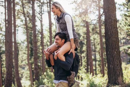 Man carrying his woman partner on his shoulders while trekking i