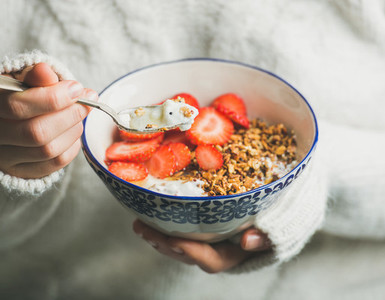 Healthy breakfast yogurt granola strawberry bowl in woman039s hands