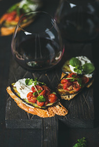 Brushetta with eggplant  tomatoes  garlic  cream cheese  arugula  glass of wine