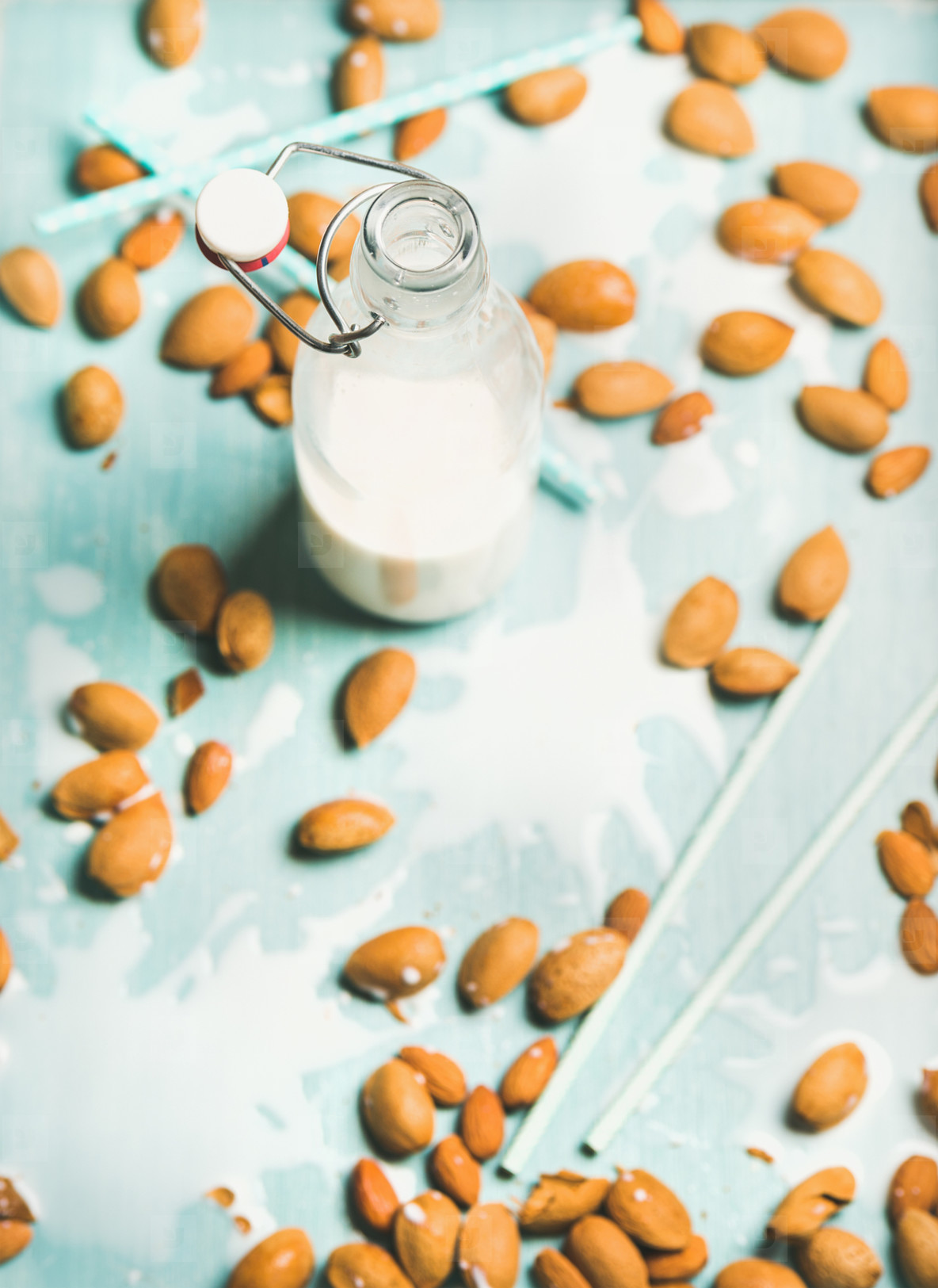 Dairy alternative almond milk in bottle over blue background