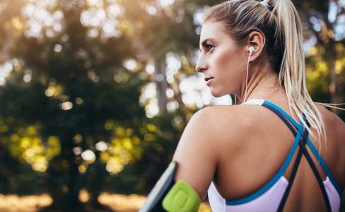 Woman runner wearing earphones during workout