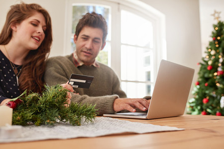 Couple shopping online with credit card for Christmas