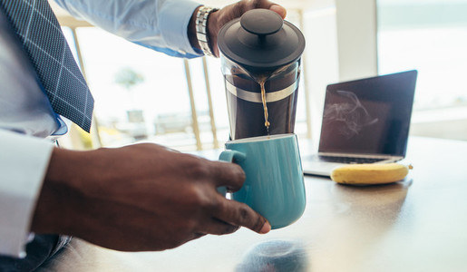 Man pouring hot coffee in a mug