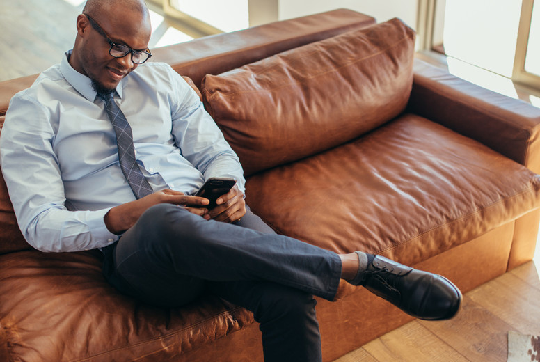 Businessman sitting on lounge using mobile phone