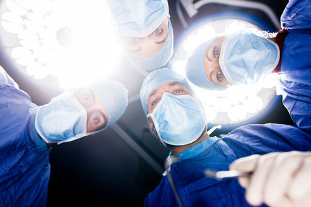Surgeons under surgery lights in operating theatre