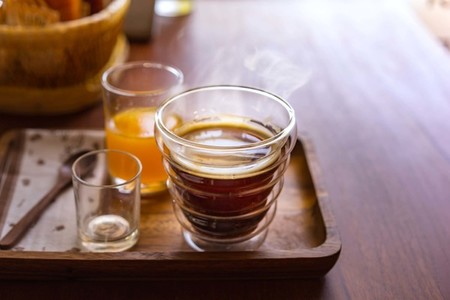 Hot americano coffee with orange juice on wooden table