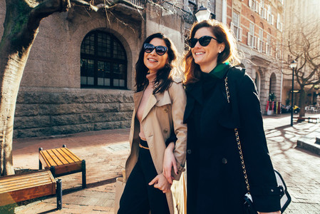 Two women walking outdoors and smiling