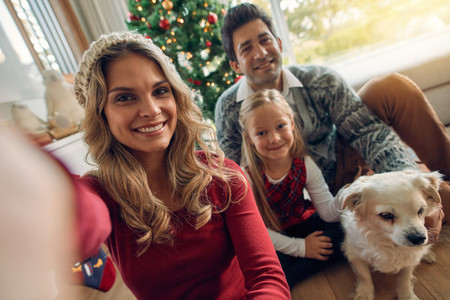 Caucasian family taking photos at Christmas