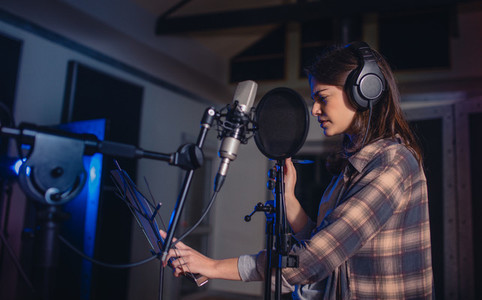 Woman recording music in studio