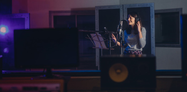Woman recording a song in music studio