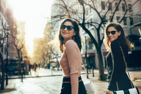 Two women walking together on the city street