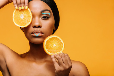 Woman with vivid makeup and orange slices