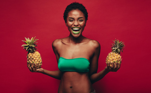 Laughing african woman with pineapples