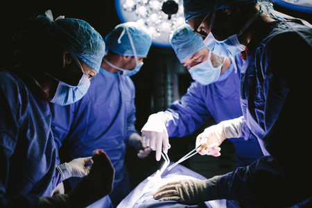 Medical team performing surgical procedure in operating theater