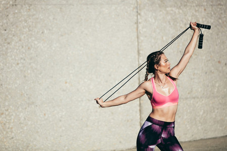 Strong woman in stretching with skipping rope