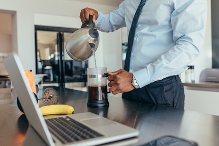 Businessman preparing coffee at home