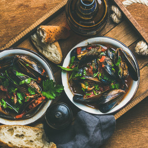 Belgian boiled mussels in tomato sauce with parsley in tray