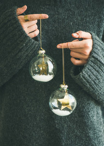 Woman in grey warm woolen sweater holding toy glass balls